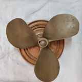 Bronze boat propeller on wood