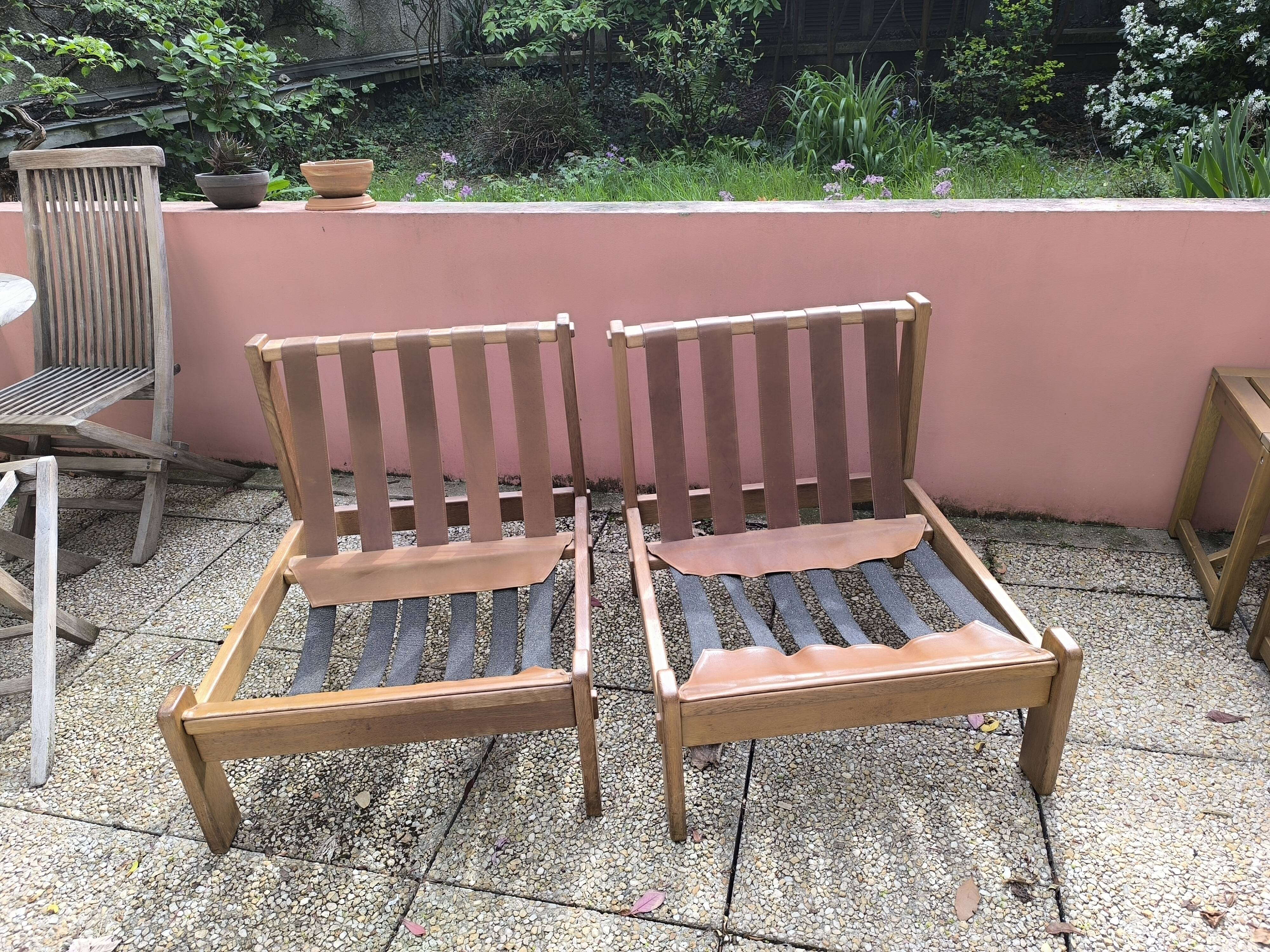 Pair of solid wood and leather lounge chairs, European work, circa 1970.