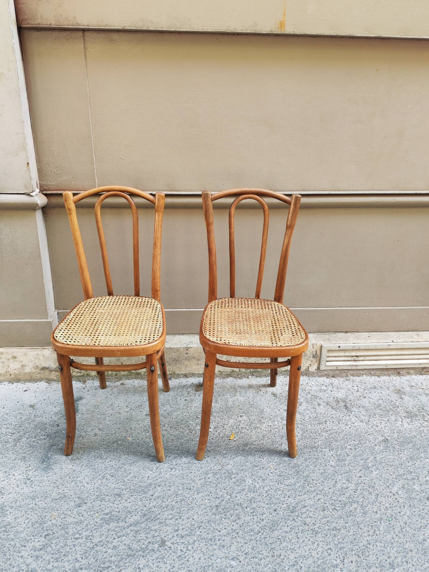 Pair of vintage bistro chairs in curved wood and caning.
