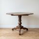 Antique wooden gueridon with a scalloped top.