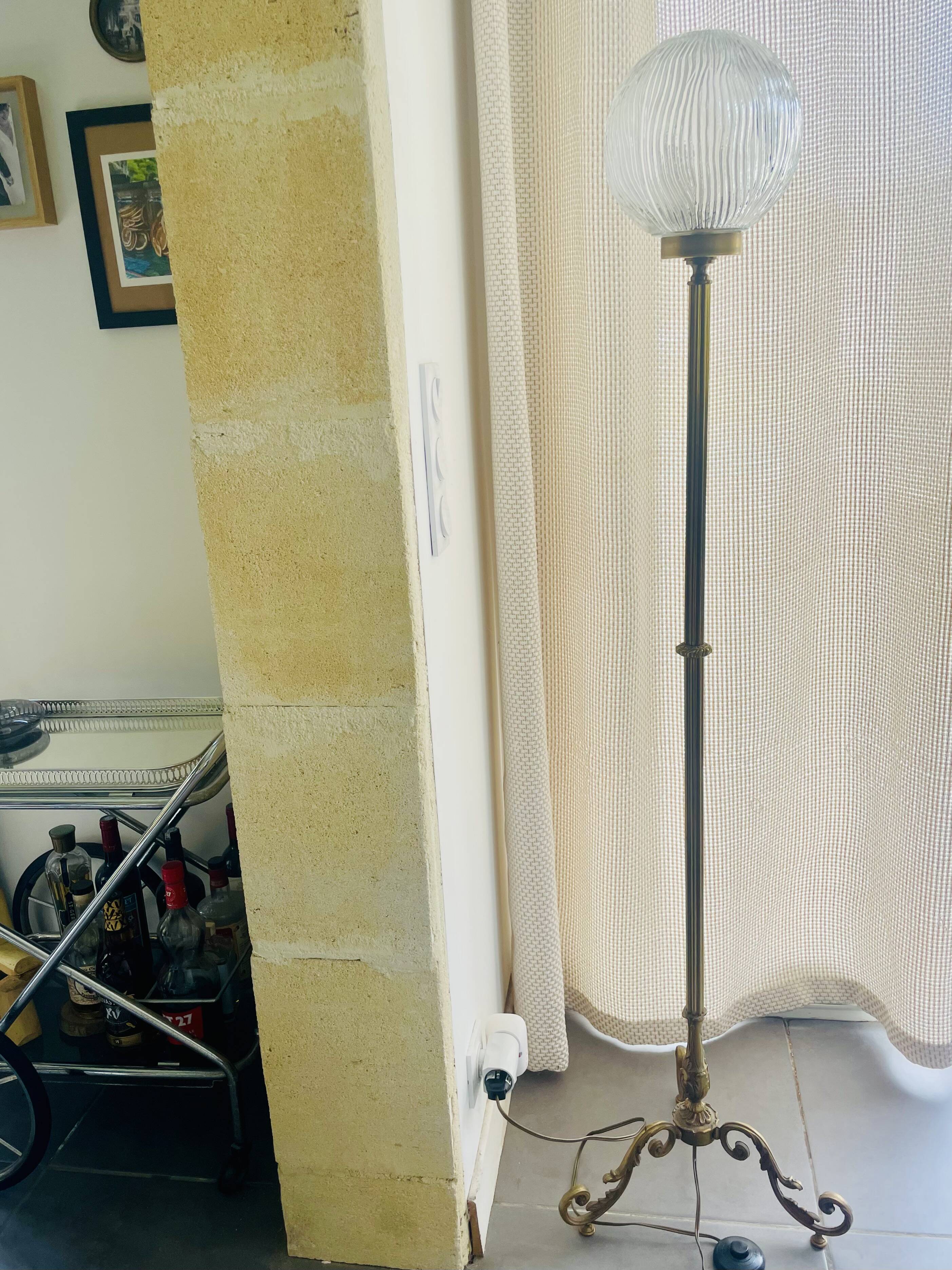 Floor lamp in gilded brass and round glass globe