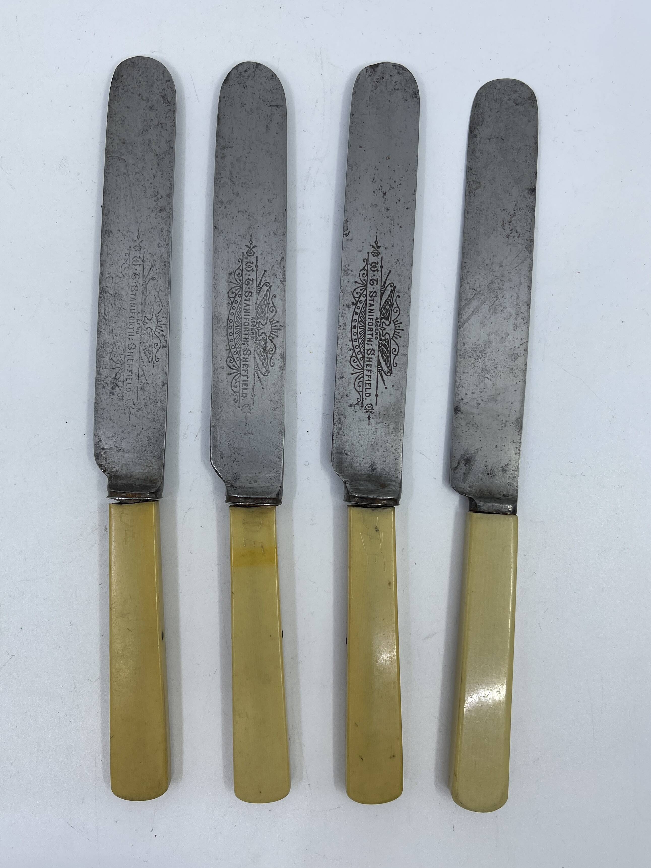 Set of 4 dessert knives with rounded tips and smooth ivory resin handles.
