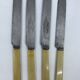 Set of 4 dessert knives with rounded tips and smooth ivory resin handles.