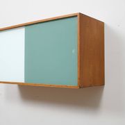 A vintage mid century wall hung bookcase/cabinet with glass sliding doors