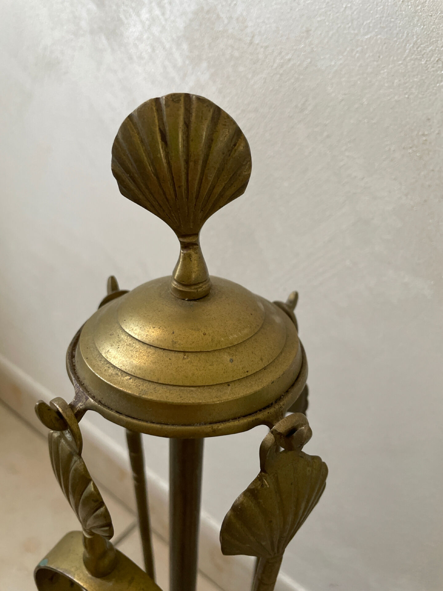 Vintage brass fireplace tool set with shell decoration.