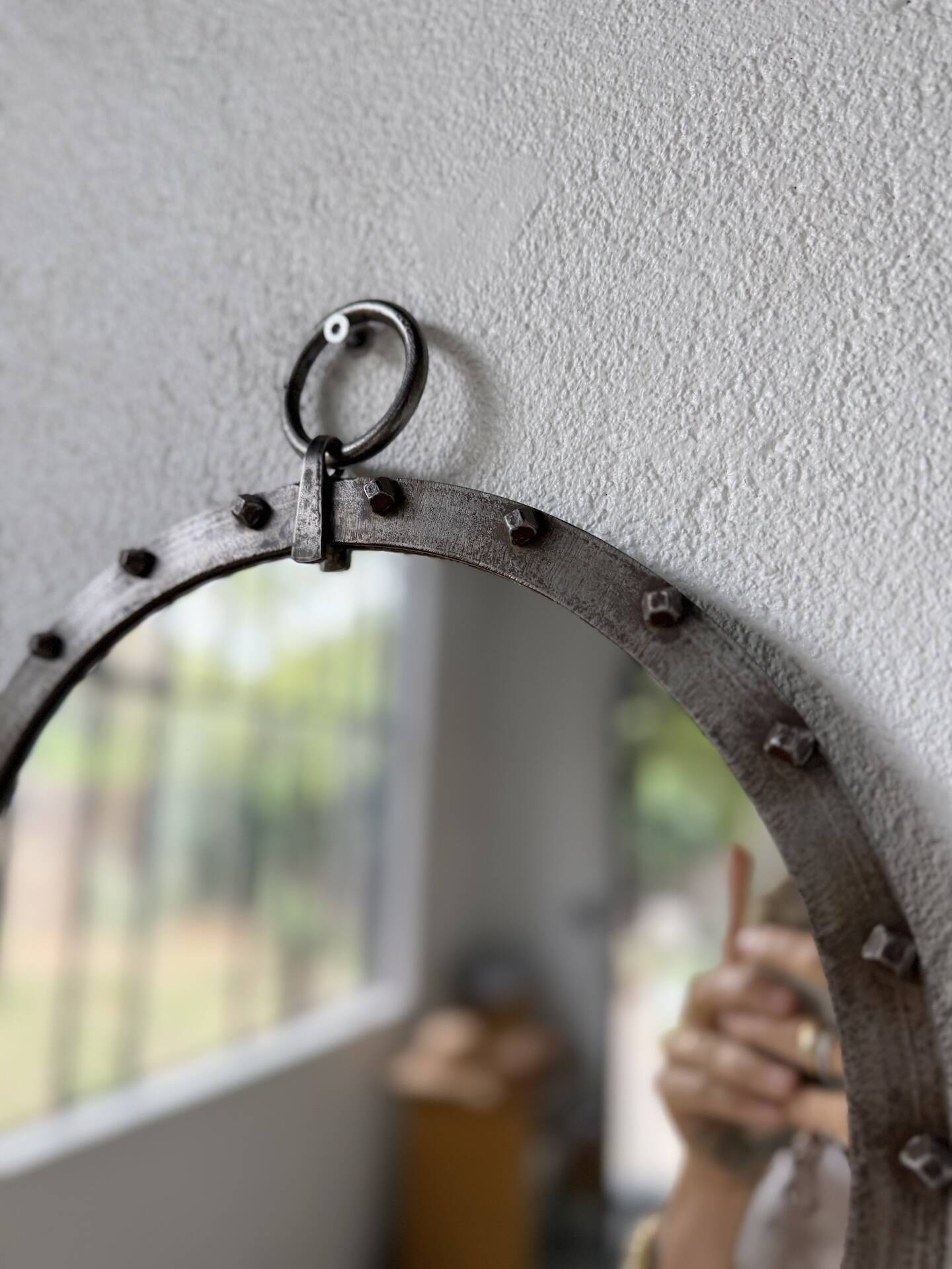 Brutalist round mirror with wrought iron and studs.