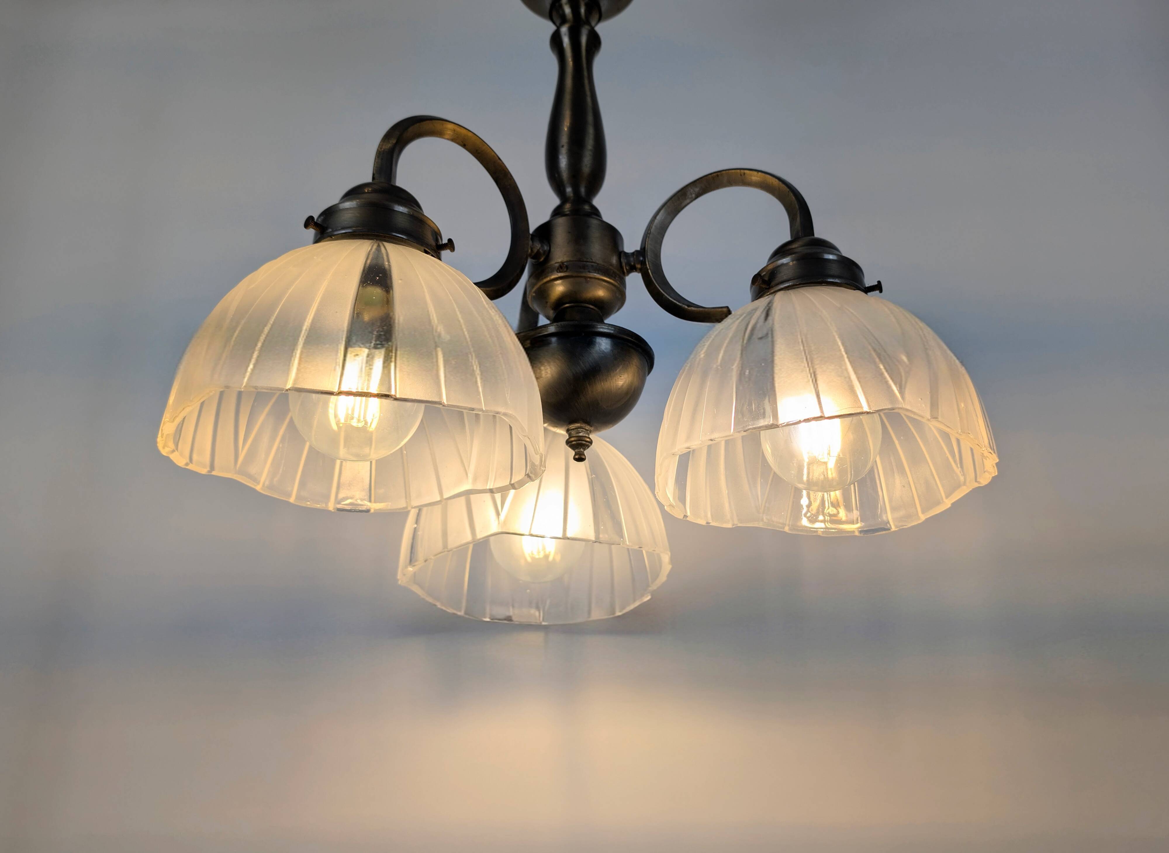 Antique Art Deco chandelier with 3 arms in patinated metal and ribbed glass.