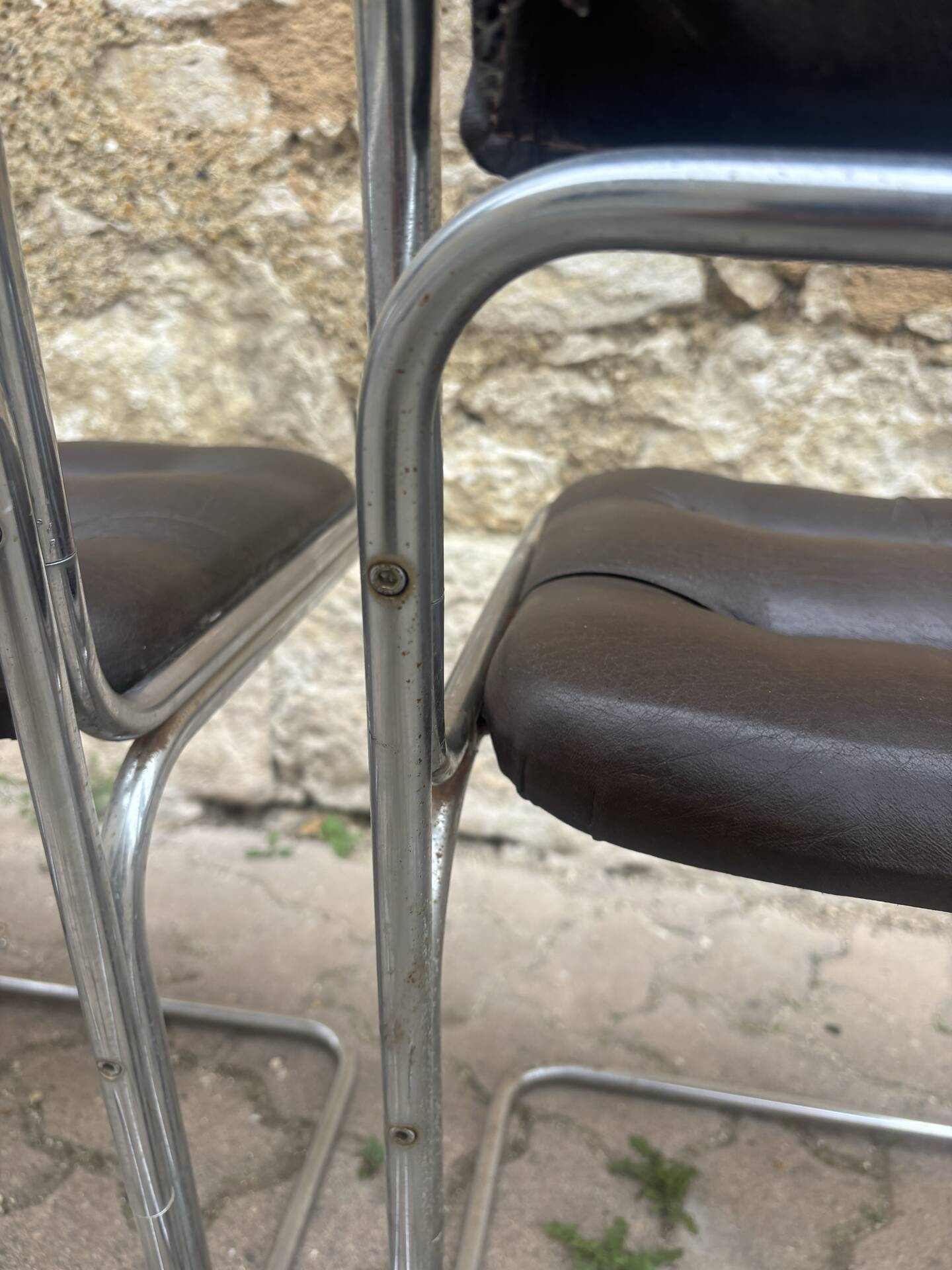 Four vintage chairs from the 1960s and 1970s, chrome with faux leather.