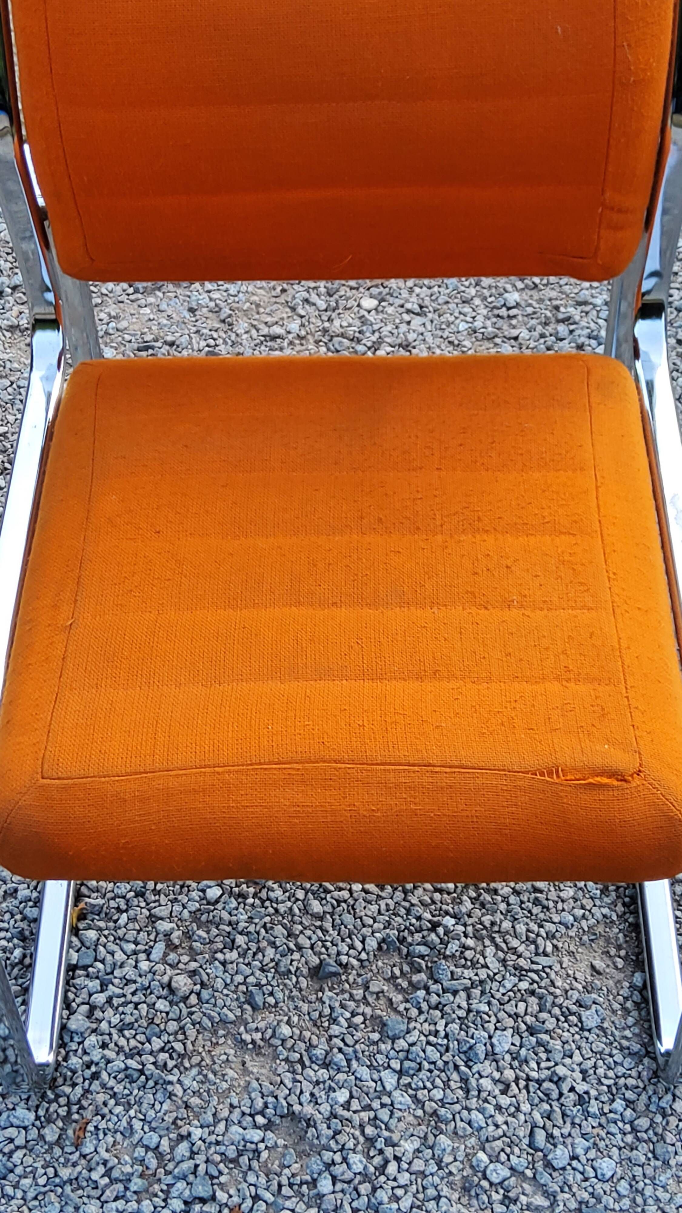 Pair of designer armchairs in orange fabrics and chrome tubes from the 70s