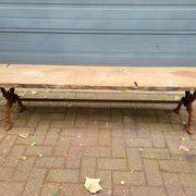 French country-style cast iron garden bench with old barn wood plank.