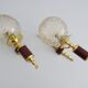 Golden wall lamps with round glass shades and teak veneer