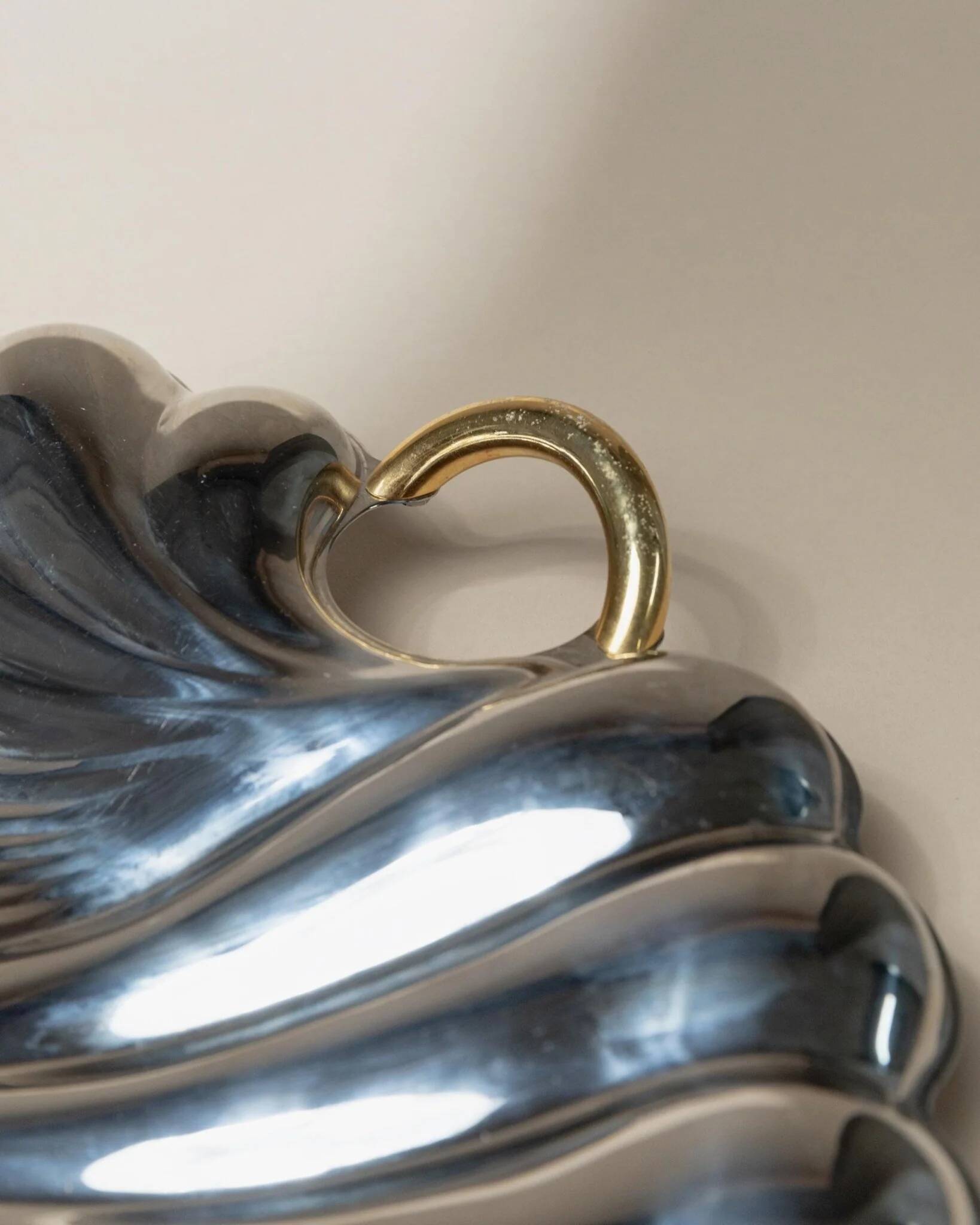 Plateau en acier inoxydable poli argenté en forme de coquillage avec poignées dorées, Becchetti Italie années 1980.