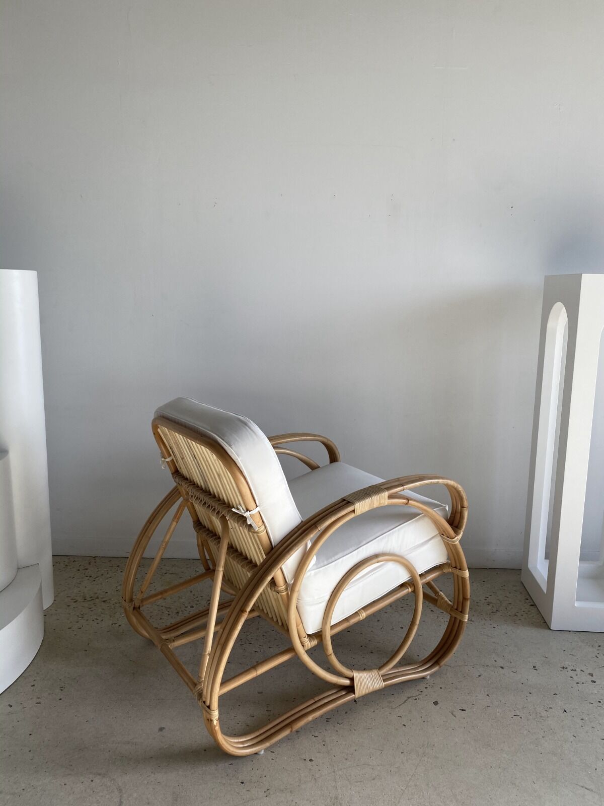 Large rattan rest chair and white cushions