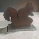 Squirrel bookends in rusty metal on a steel base.