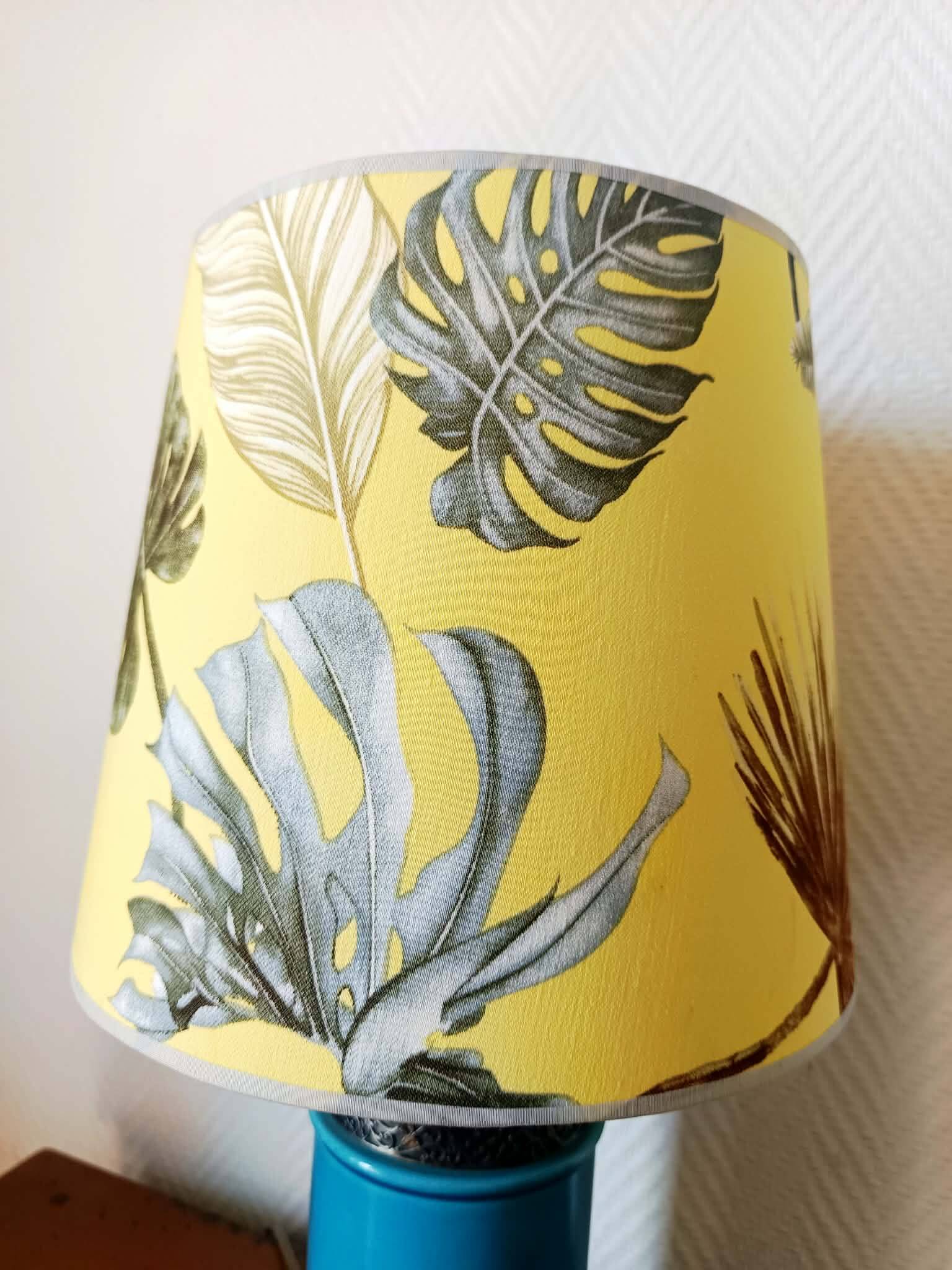 Blue ceramic lamp with claw feet and foliage lampshade.