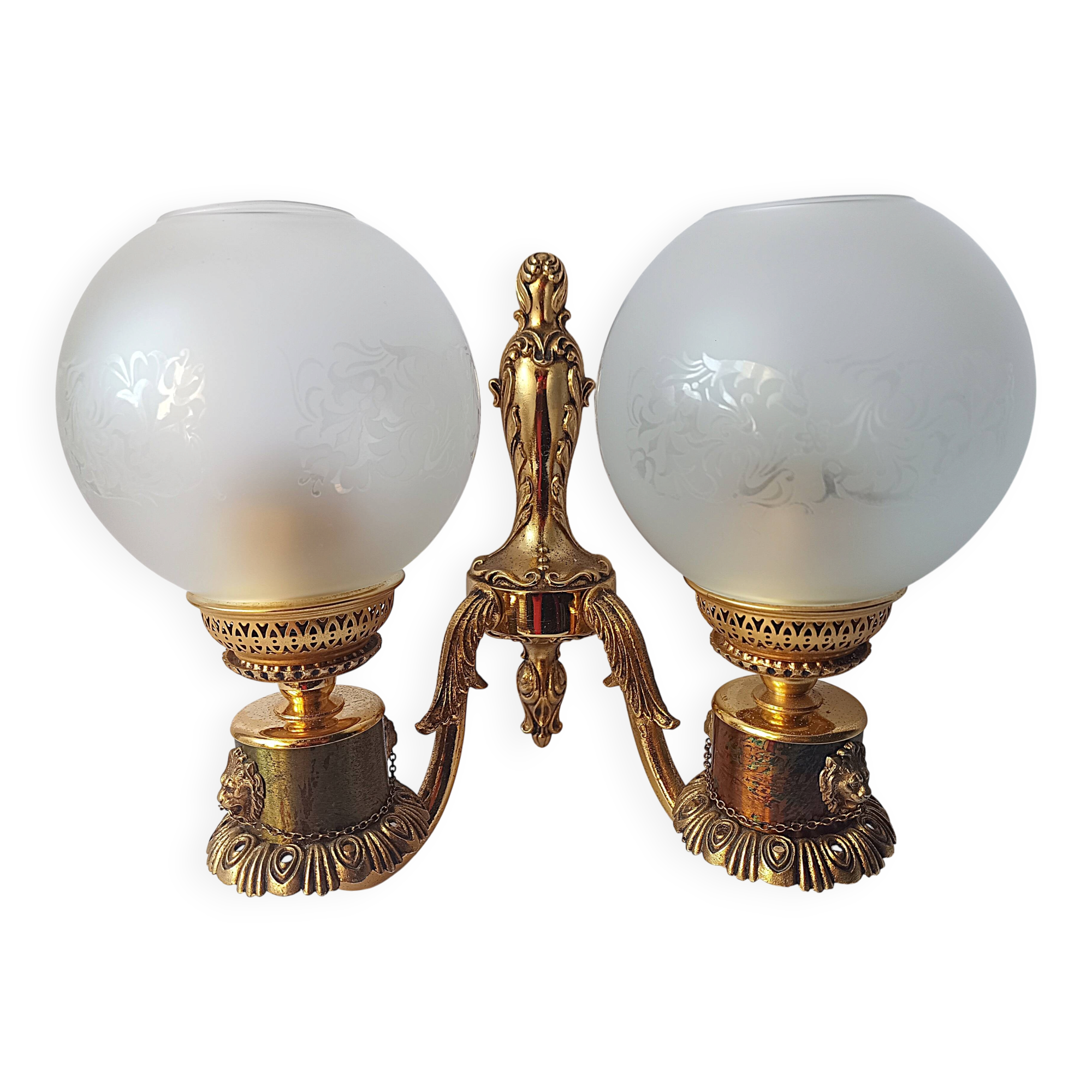Wall lamp in gilded bronze with a lion's head and engraved globe.