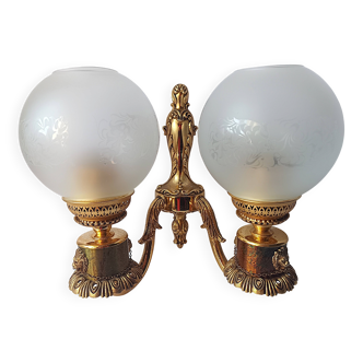 Wall lamp in gilded bronze with a lion's head and engraved globe.