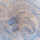 pair of round wooden chairs with a pattern on the seat