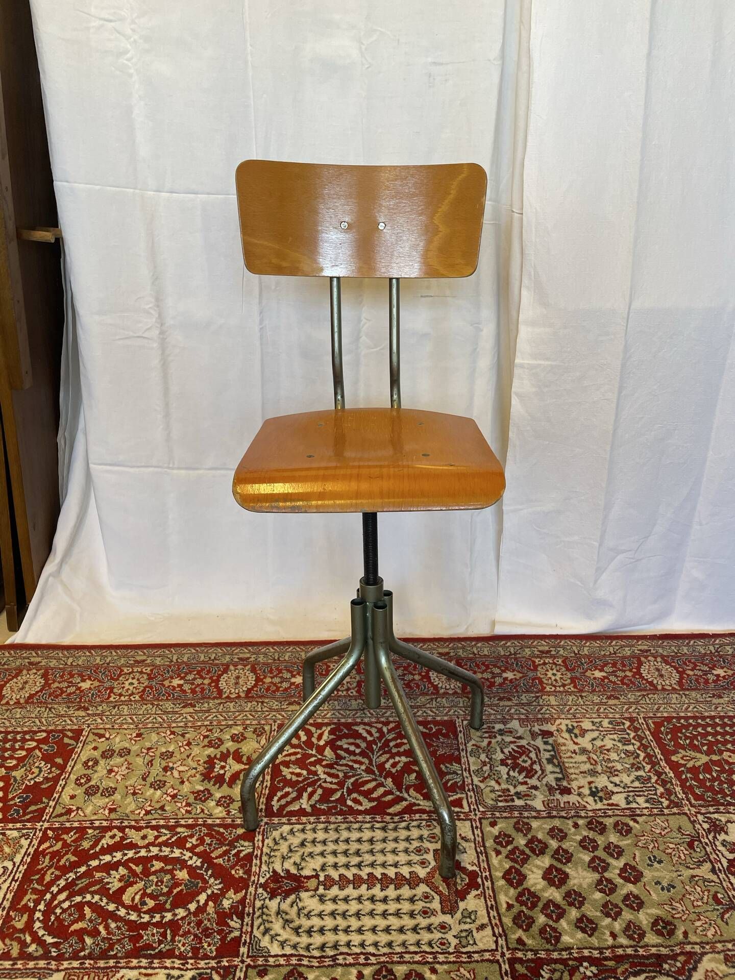 Old high workshop chair made of wood and metal.