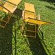 2 vintage Chilean deck chairs made of wood and yellow fabric printed with sailboats, with footrests.