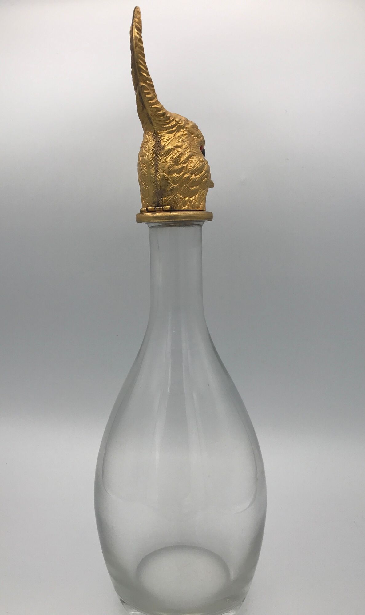 Glass bottle type carafe with gold metal bird head stopper