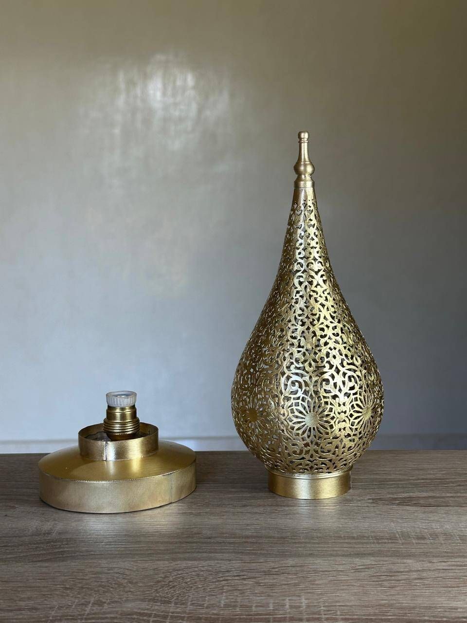 Handmade brass table lamp with a perforated drop-shaped shade.
