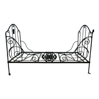 Green forged iron folding bed with cherub medallion