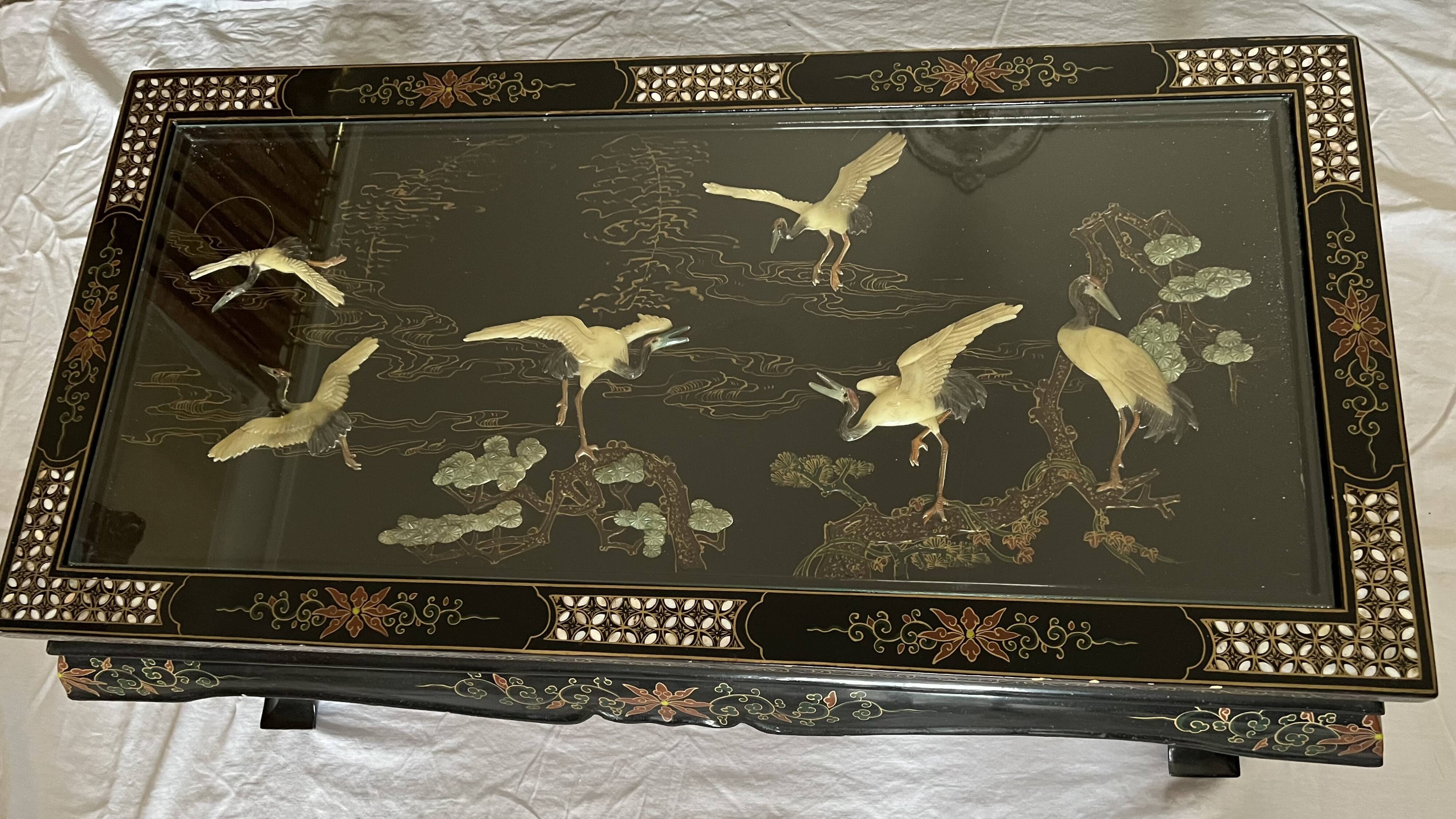 Chinese black wood table inlaid with mother-of-pearl featuring a relief scene of a crane.