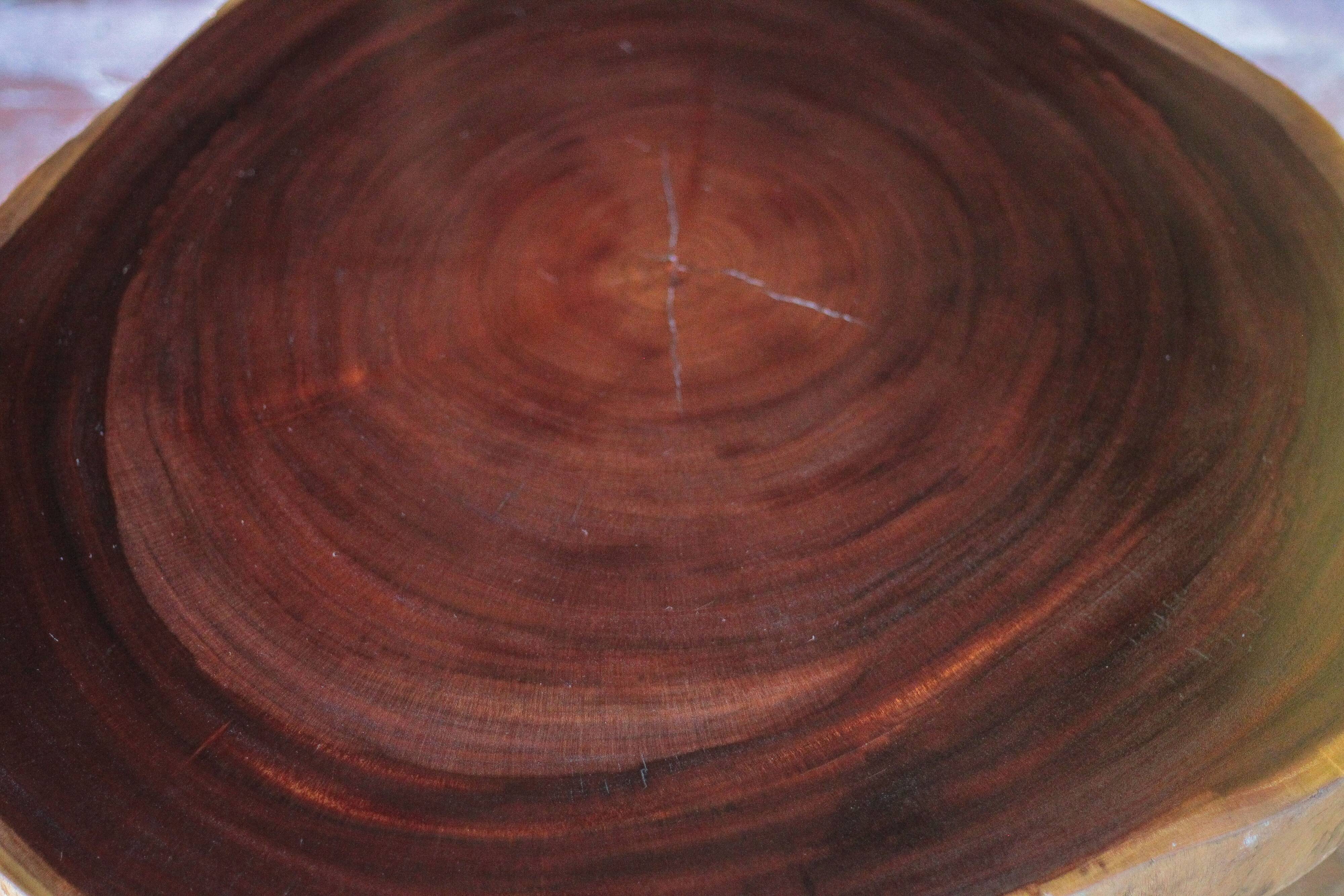 Brutalist wooden coffee table, cruciform leg with a tree trunk top.