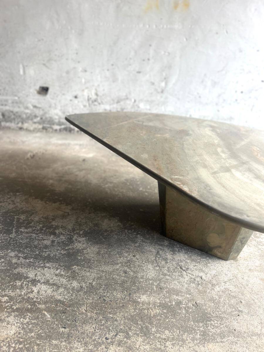 Light gray solid granite coffee table with organic triangular shape and conical base, 1980s