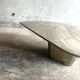 Light gray solid granite coffee table with organic triangular shape and conical base, 1980s
