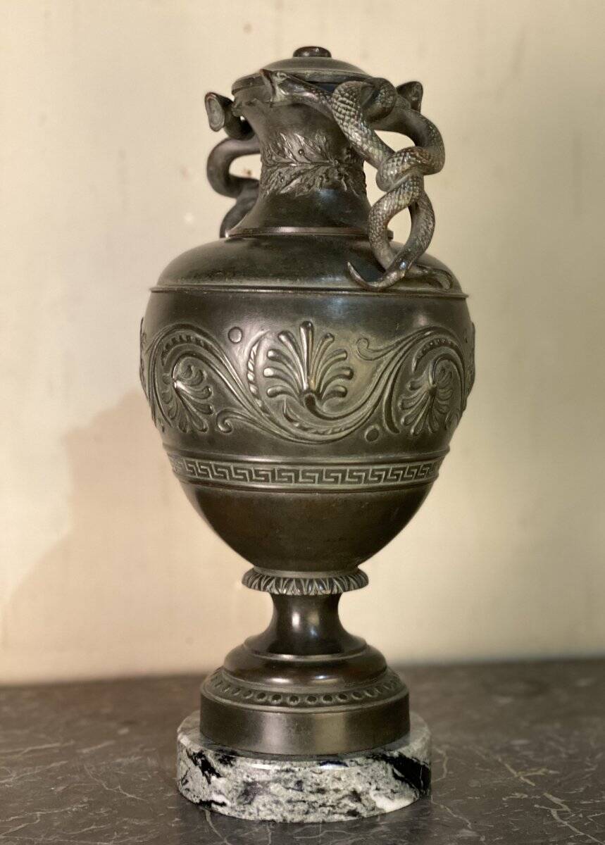 Bronze vase with snakes and a green patina, in the antique style.