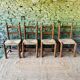 Set of 4 solid wood chairs with straw seats.