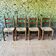 Set of 4 solid wood chairs with straw seats.