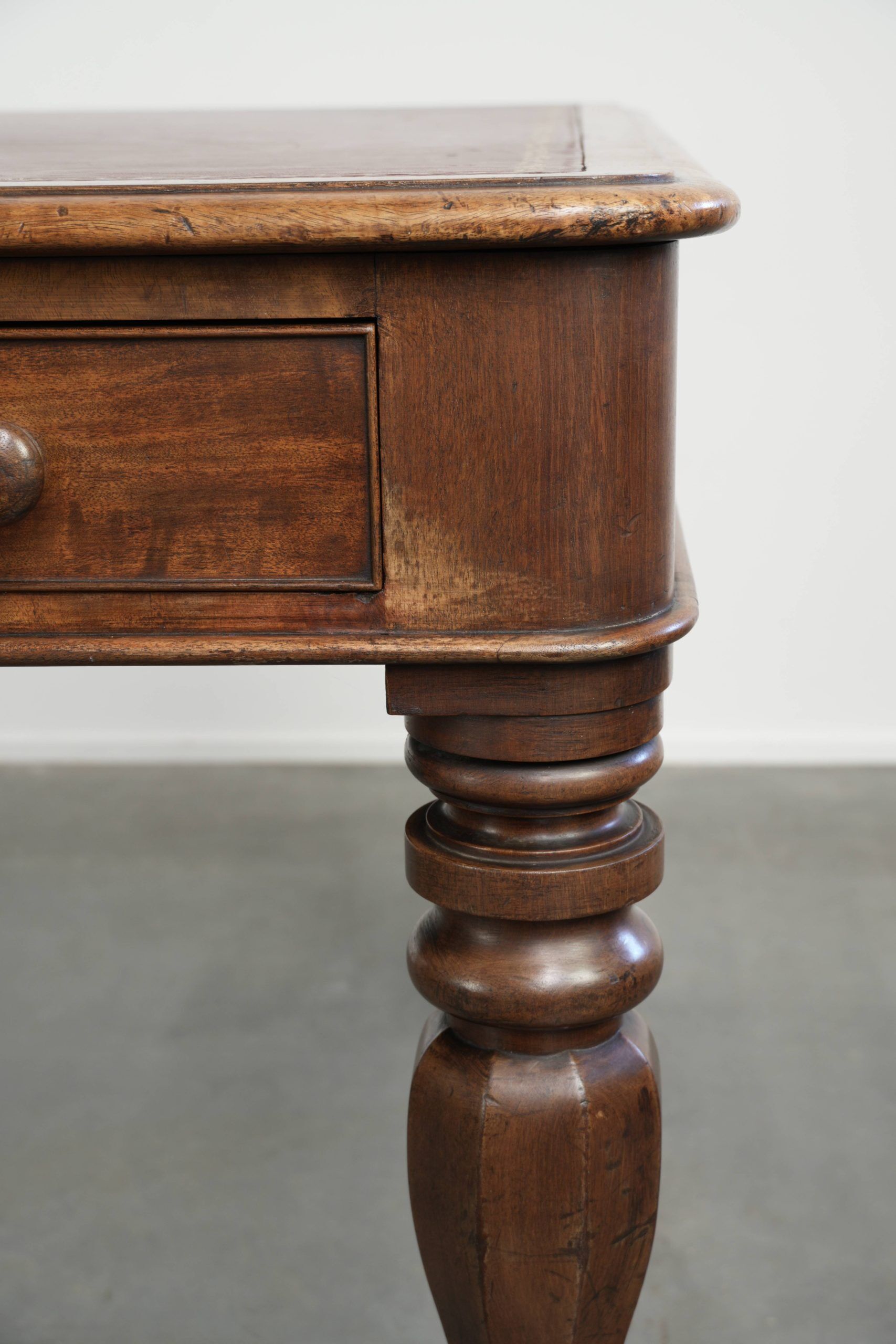 Antique English writing desk from the 19th century with a red leather top
