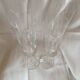 4 crystal champagne flutes with feet decorated with two knots.