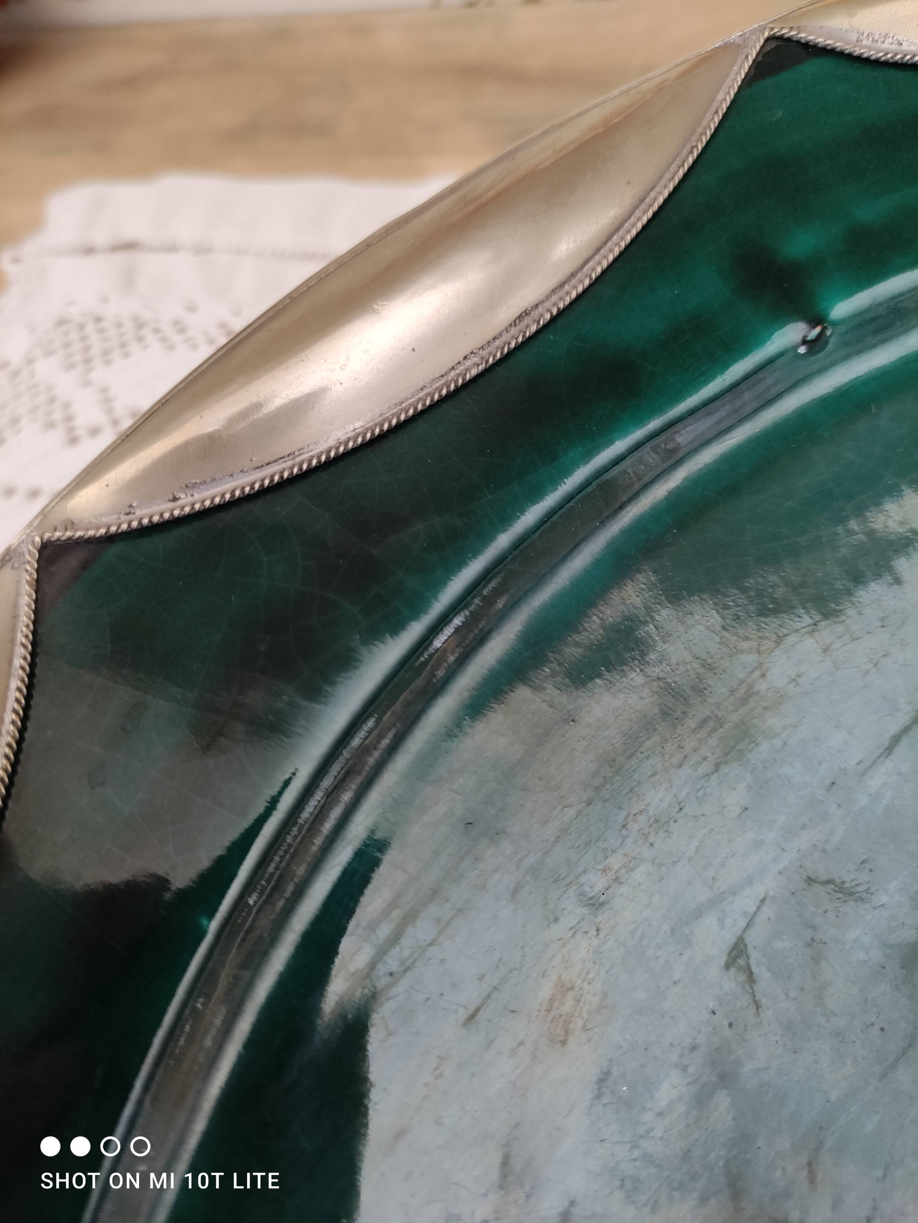 Round oriental hollow dish in deep green ceramic and silver colored metal