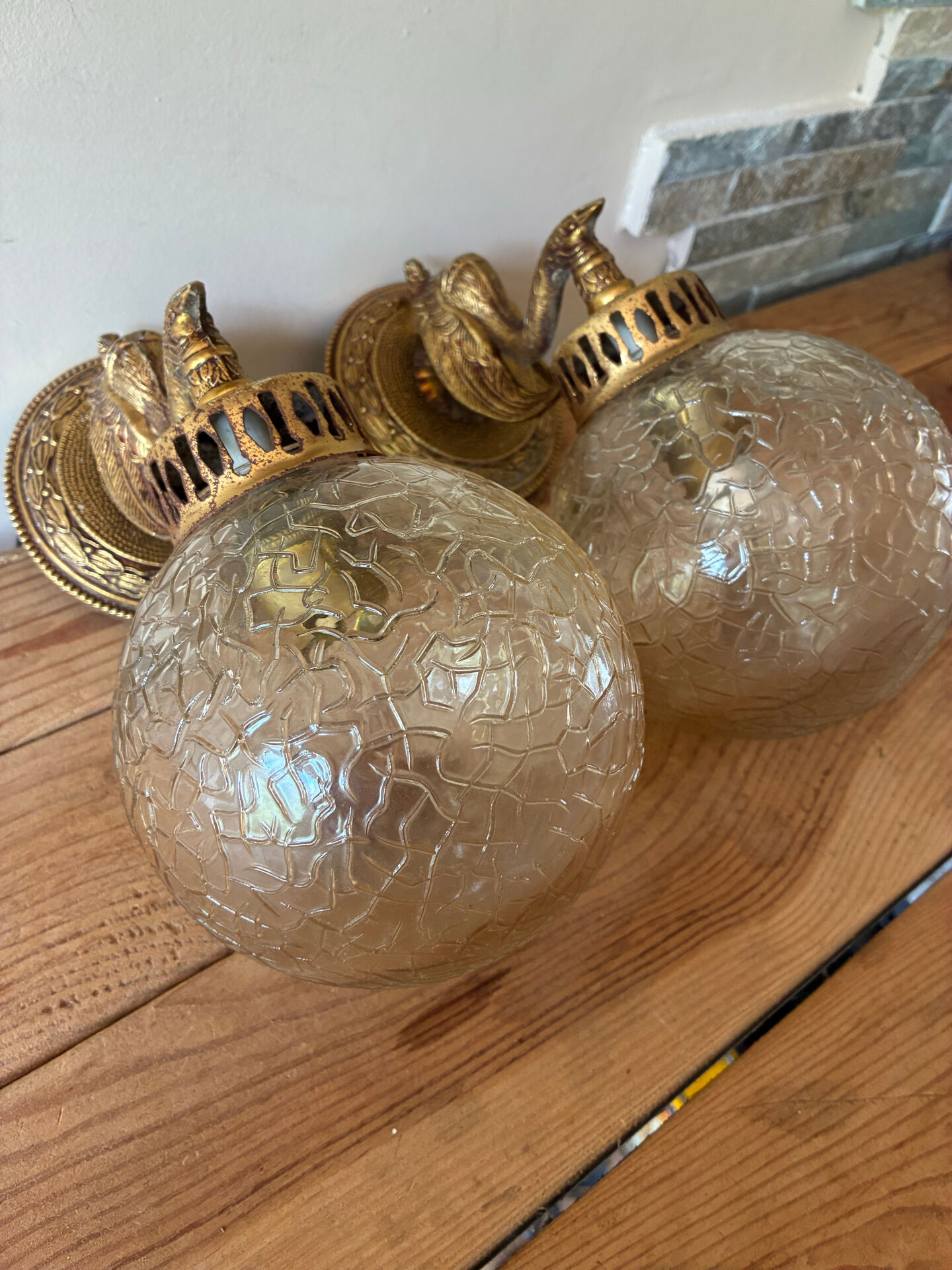 Pair of vintage wall sconces with golden metal swan heads and glass.