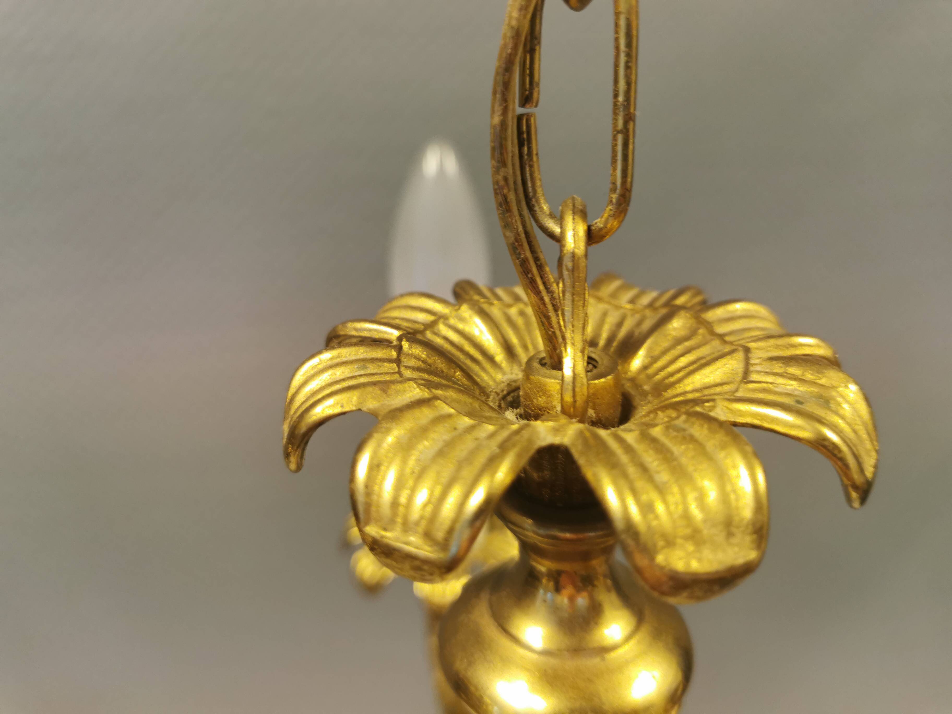 Older brass alloy chandelier with three light sources.