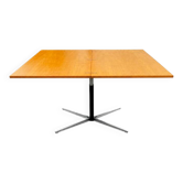 Table rises and lowers in light wood and metal.