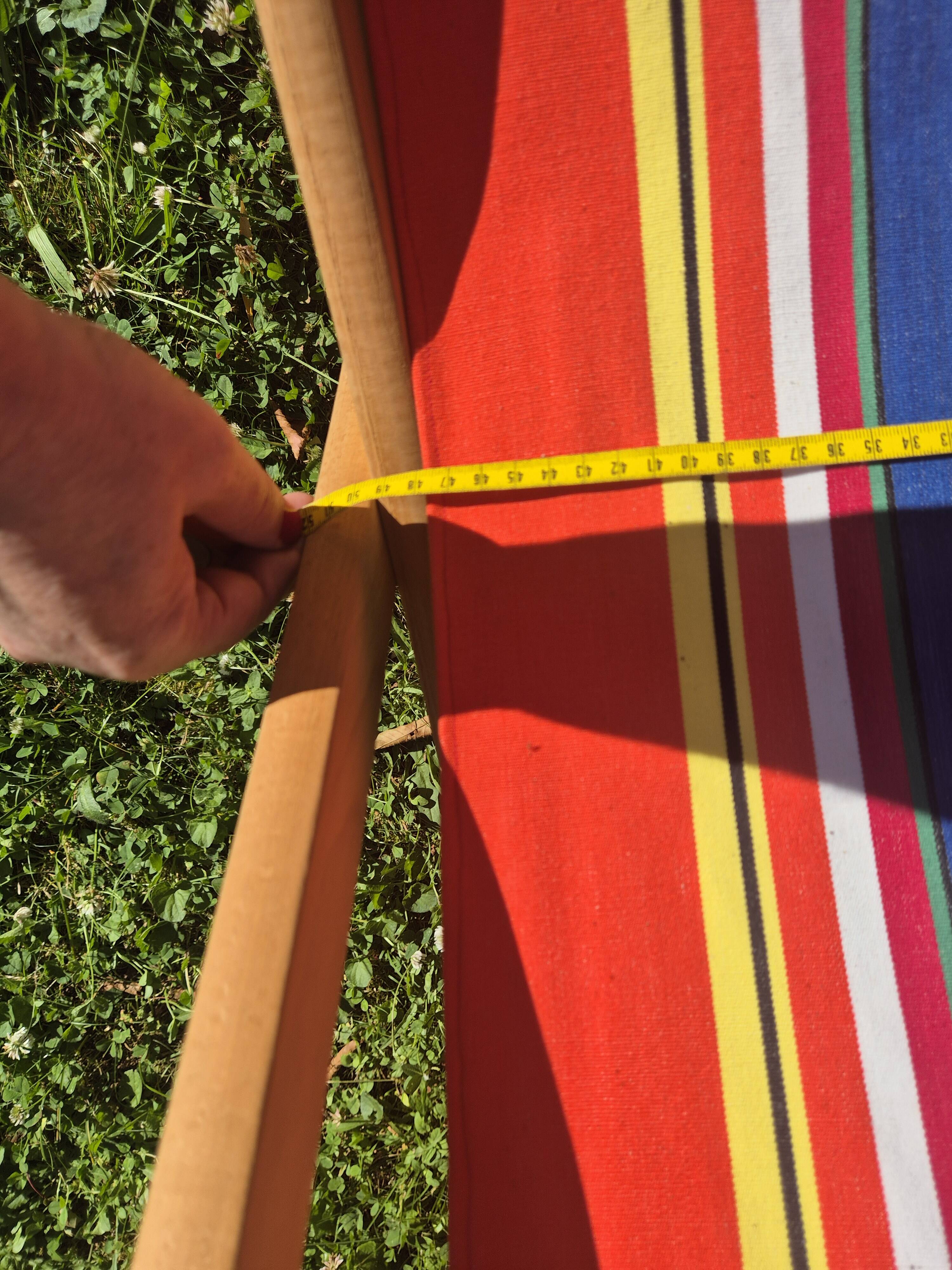 vintage wooden deck chair with red, blue, and yellow striped fabric