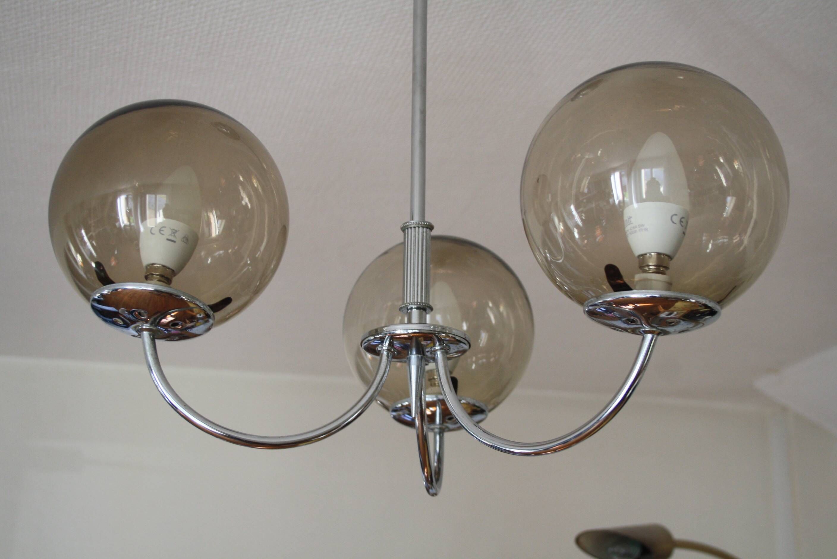 Chrome metal chandelier with smoked glass globes.