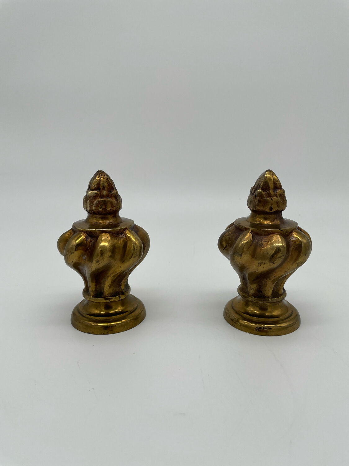 Pair of antique flame curtain rod finials in gilded bronze