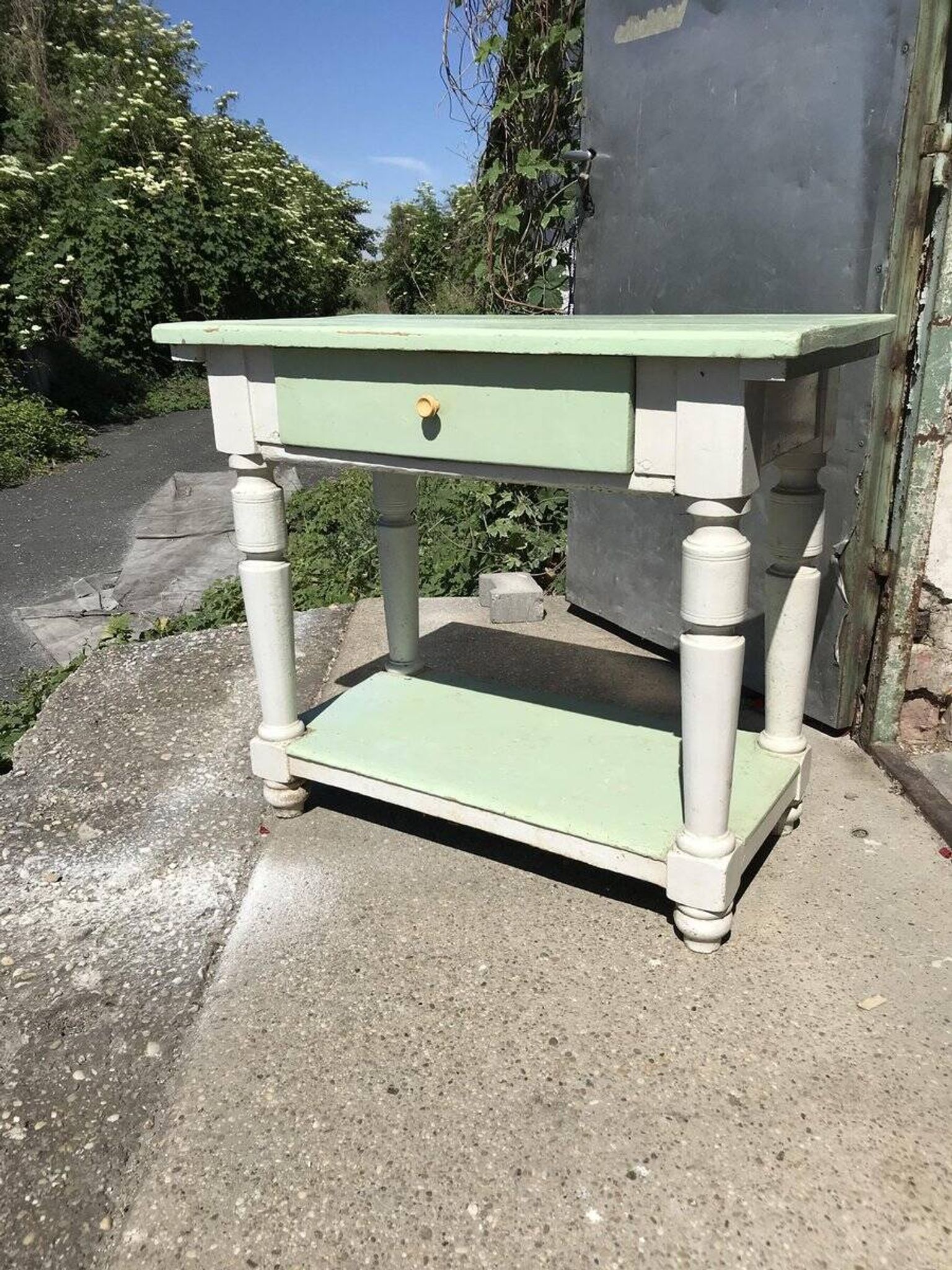 Rustic wooden dining table painted white and pale green, with a central drawer, 1950s.