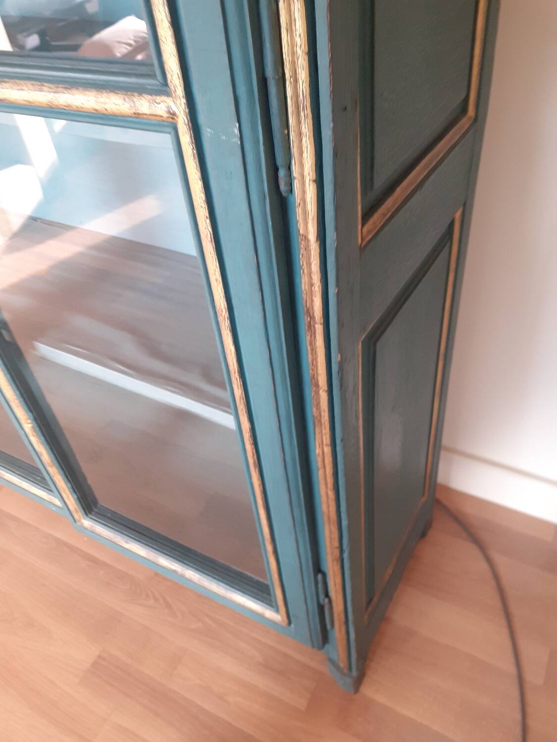 Glass-fronted cabinet in weathered green wood