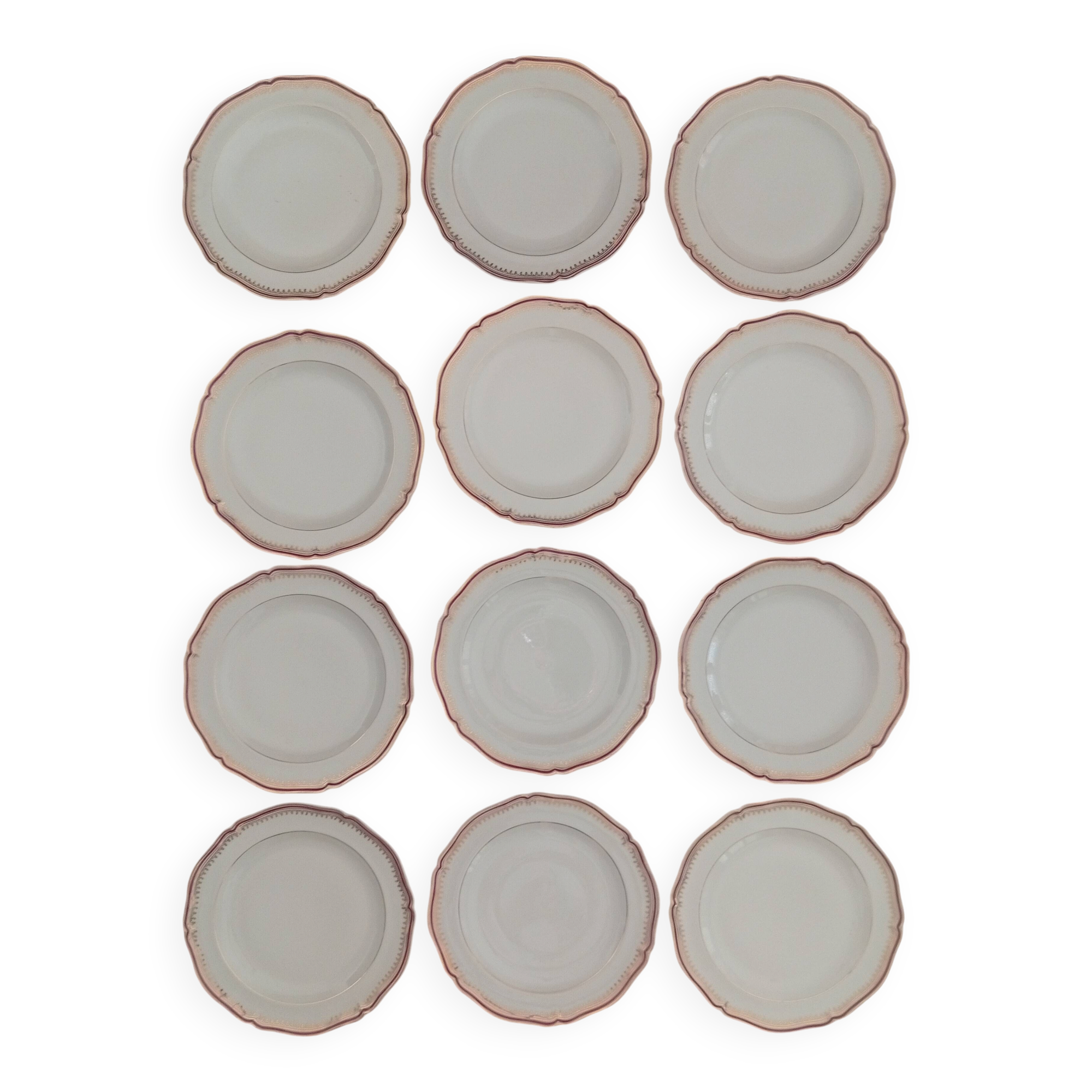 Set of 12 stylised white porcelain dinner plates, signed.