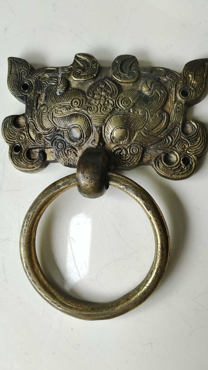 Ancient door knocker, taotié mask, shang dynasty. in bronze golden patina