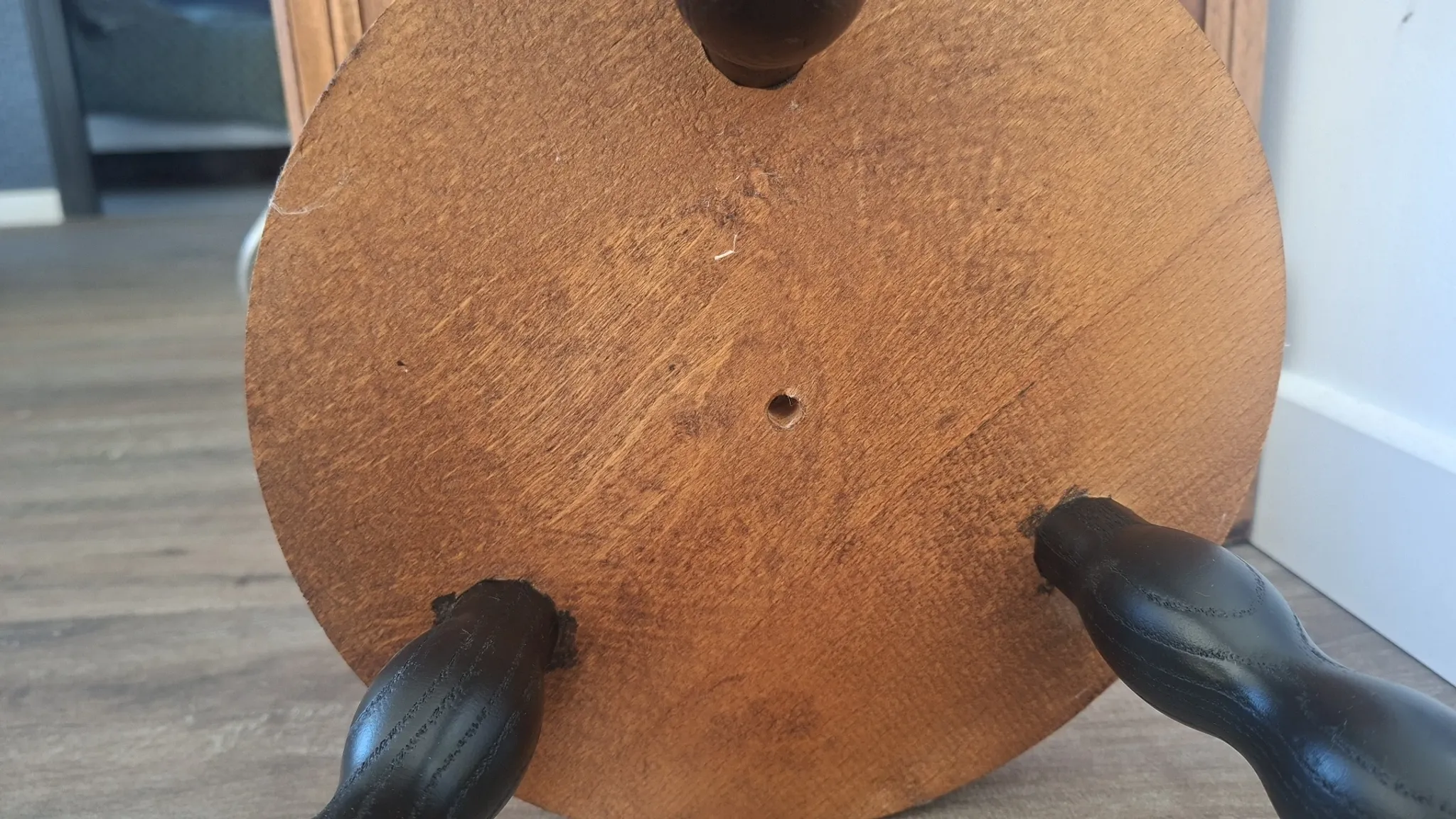 Brown and black wooden tripod stool
