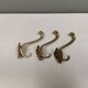 Three old and beautiful brass hooks with decorative motifs