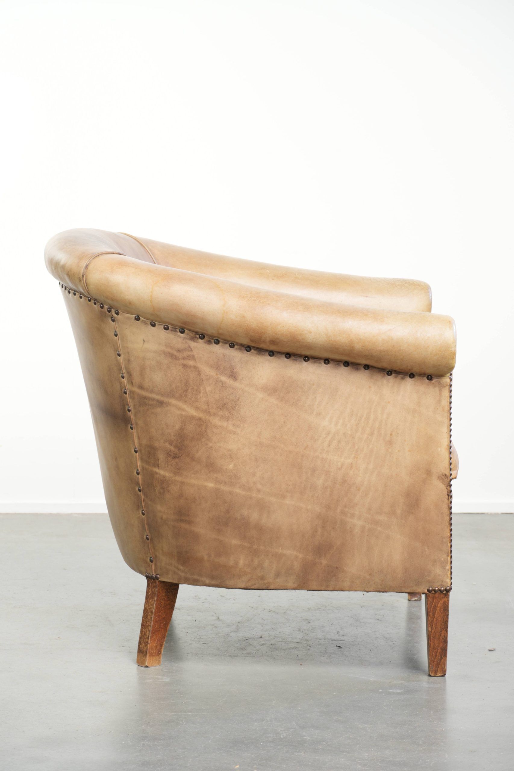 Vintage cowhide club armchair in English style in a light colour scheme